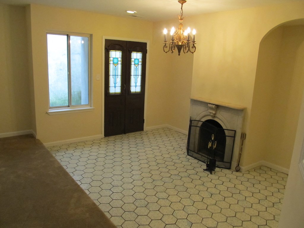 the living room has a fireplace and a tile floor