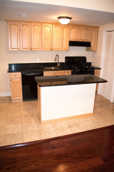 a kitchen with an island and a stove and cabinets