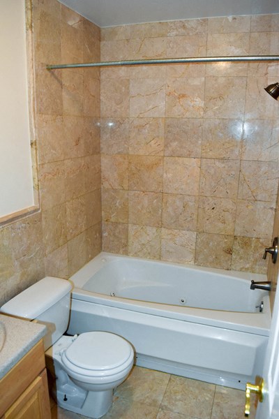 a bathroom with a toilet and a tub and a sink