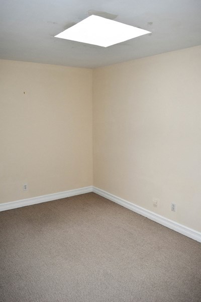 an empty room with beige walls and a window