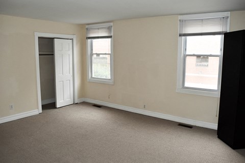 an empty room with two windows and a door