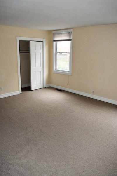 an empty living room with a door and a window