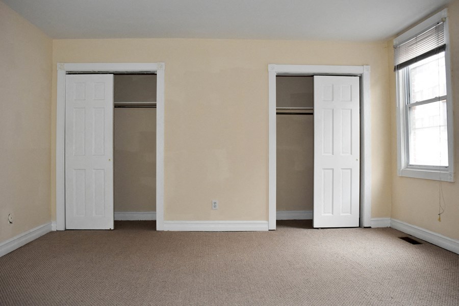 an empty living room with two doors in it
