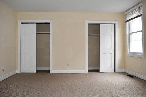 an empty living room with two doors in it