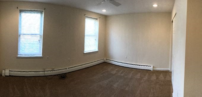 an empty room with white walls and two windows