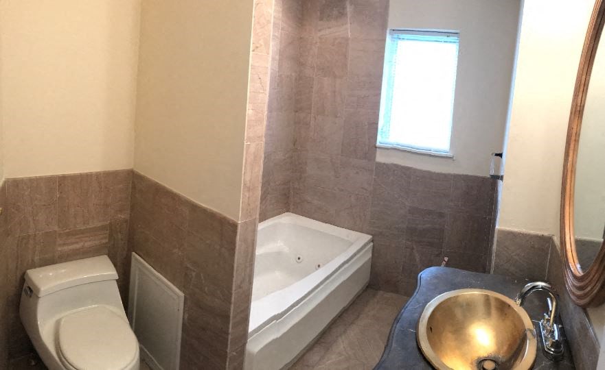 a bathroom with a toilet and a tub and a sink