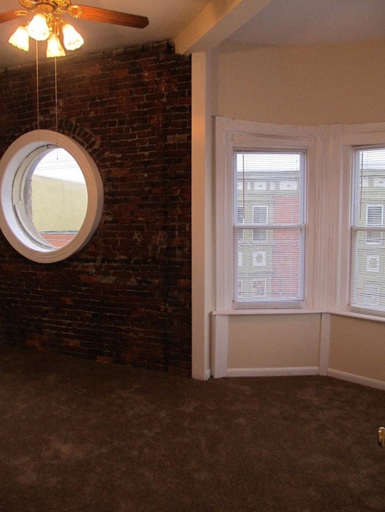 a living room with a round window and a brick wall