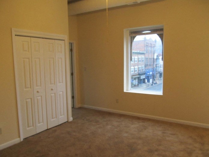 an empty living room with a window and a door