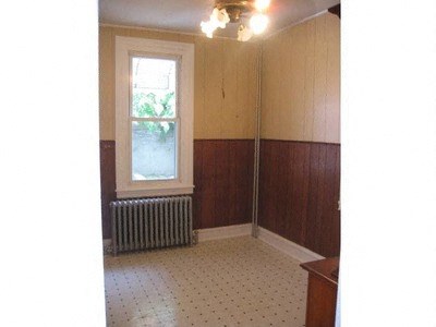 an empty room with a radiator and a window