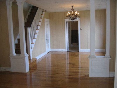 a large empty living room with a chandelier