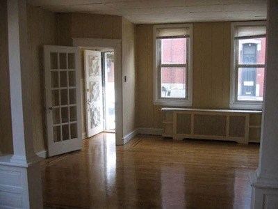 an empty living room with a door and windows