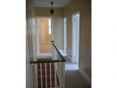 a stairway with a railing and a hallway with doors