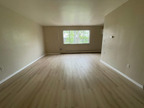 A room with wooden flooring and a window.