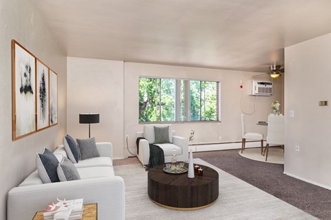 A living room with a white couch, a coffee table, and a painting on the wall.