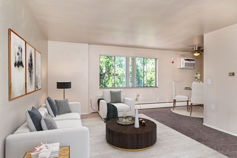 A living room with a white couch, a coffee table, and a painting on the wall.
