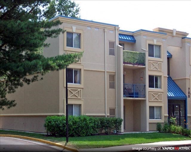 an apartment building with a lawn in front of it