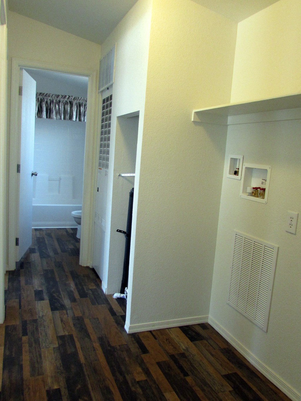 a bedroom with hardwood floors and white walls