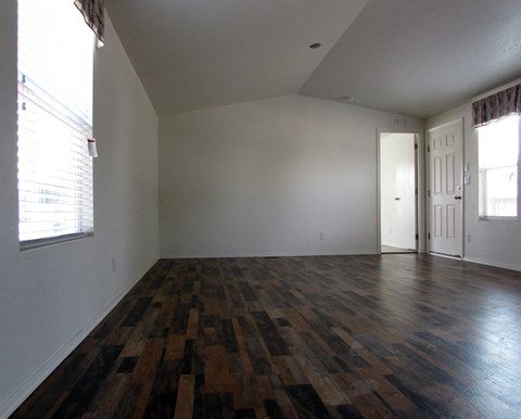 an empty living room with white walls and wood floors