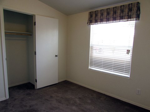 an empty room with a large window and a closet