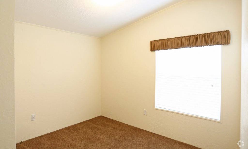 an empty room with a window and a carpet