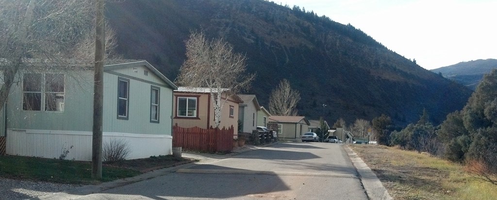 a city street with houses and a mountain in the background