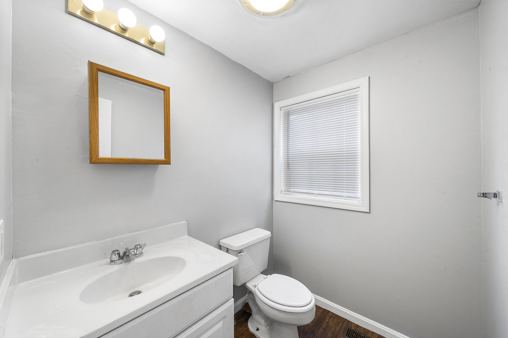a bathroom with a sink toilet and a mirror