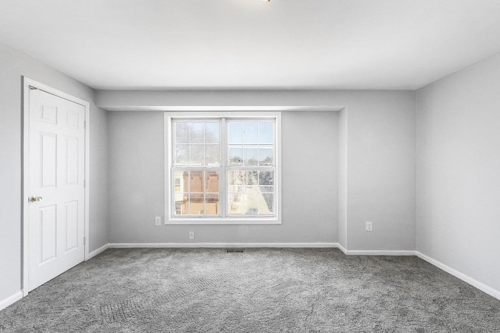 an empty room with a window and a door