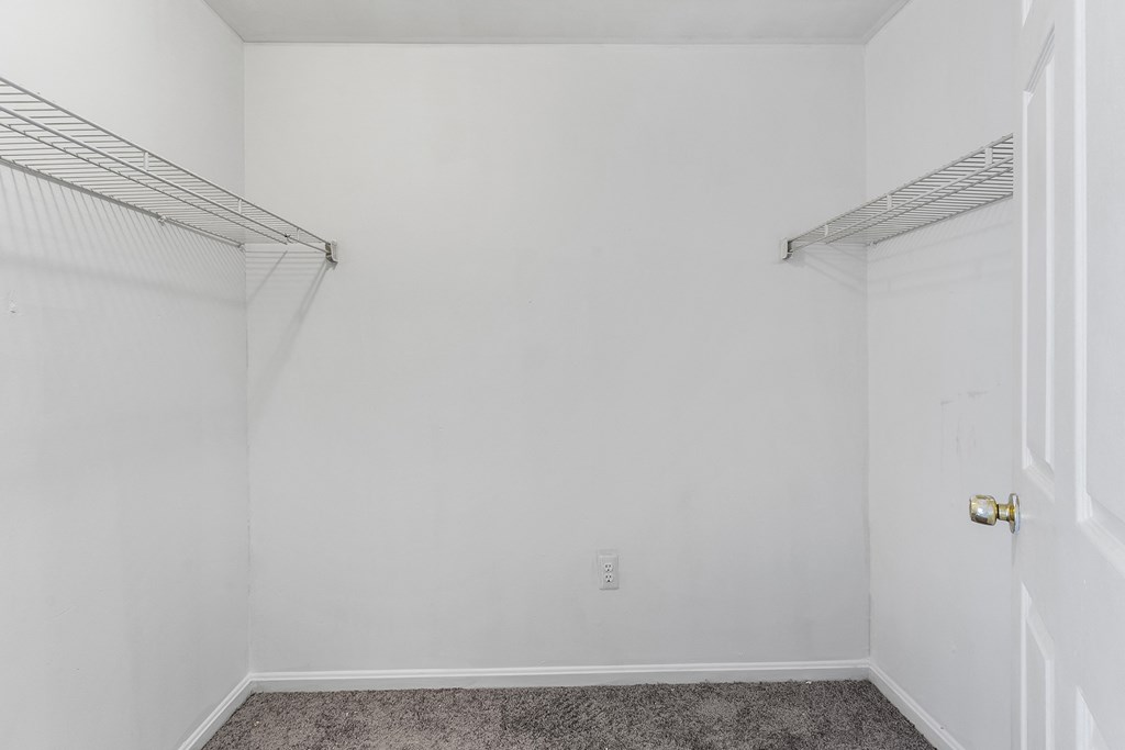 an empty room with white walls and a closet and a door