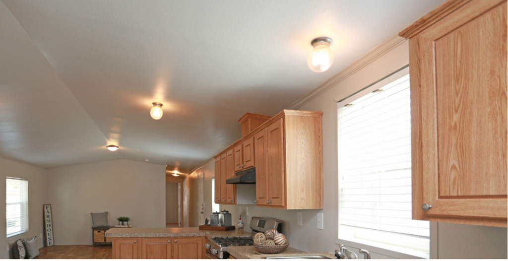 a kitchen with wooden cabinets and a large window