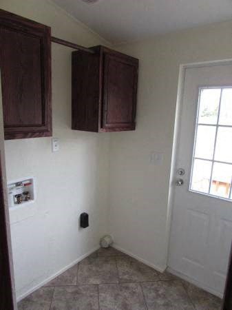 a kitchen with brown cabinets and a white door