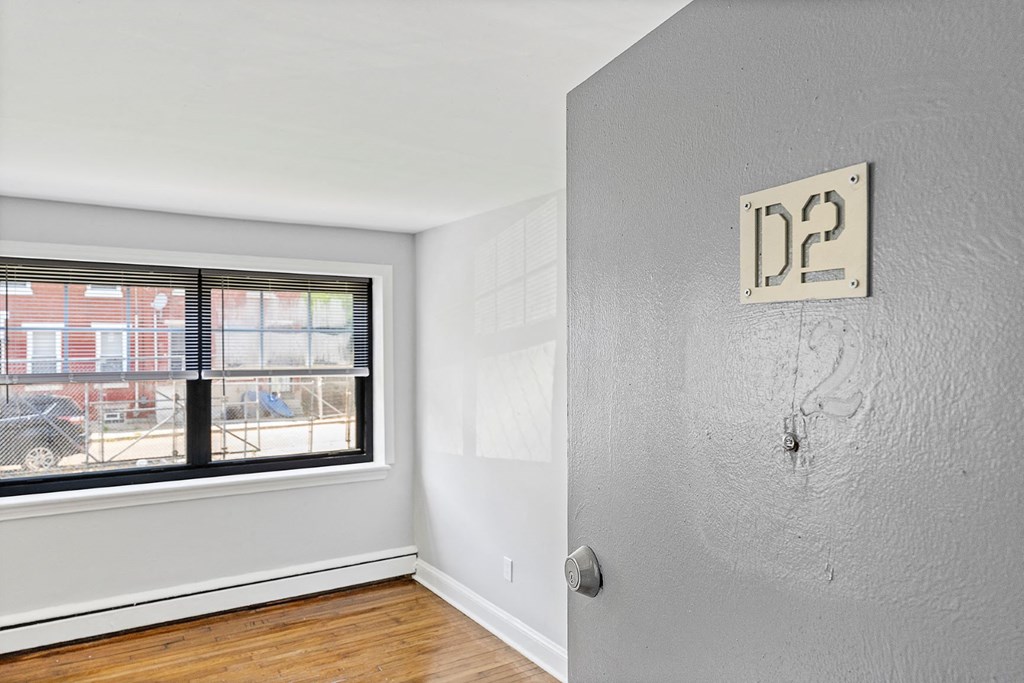 an empty room with a window and a wall with a sign on it