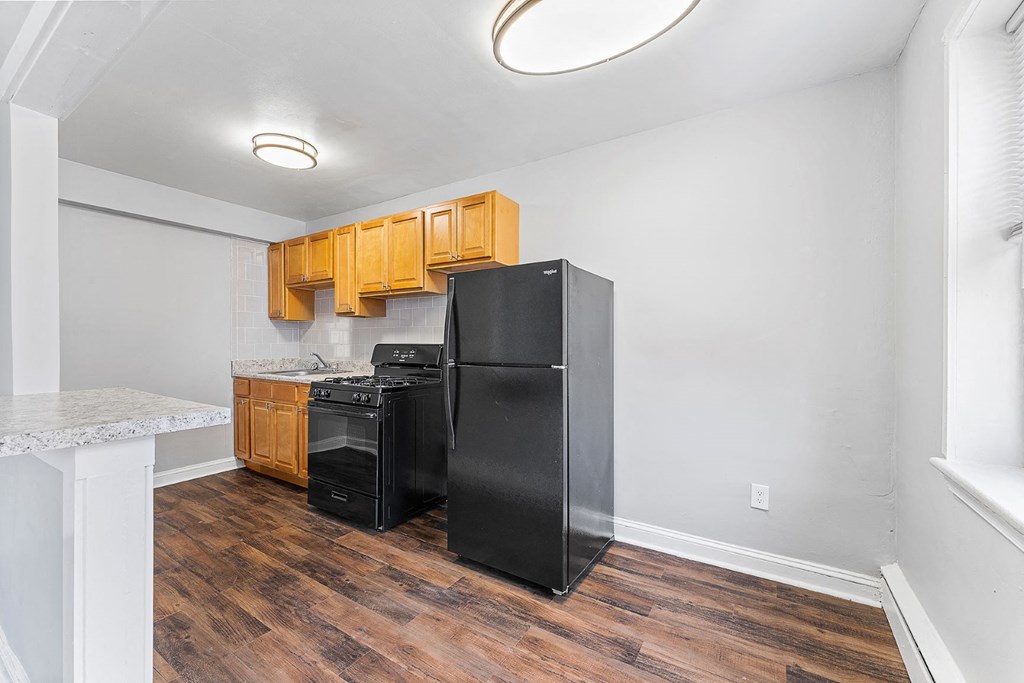 a kitchen with a black refrigerator and a stove and
