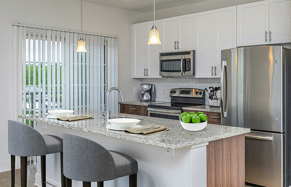 Apartment kitchen with stainless steel appliances and island with breakfast bar
