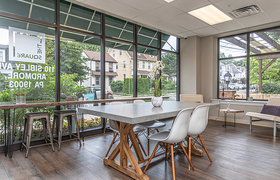 Common area with tables, chairs, and barstools in Ardmore, PA boutique apartment building