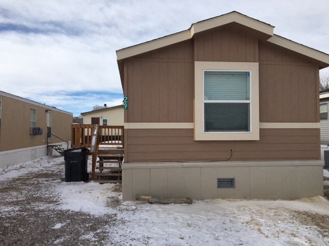 a small brown house with a garage in the snow