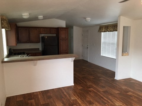 an empty kitchen and living room with wood flooring