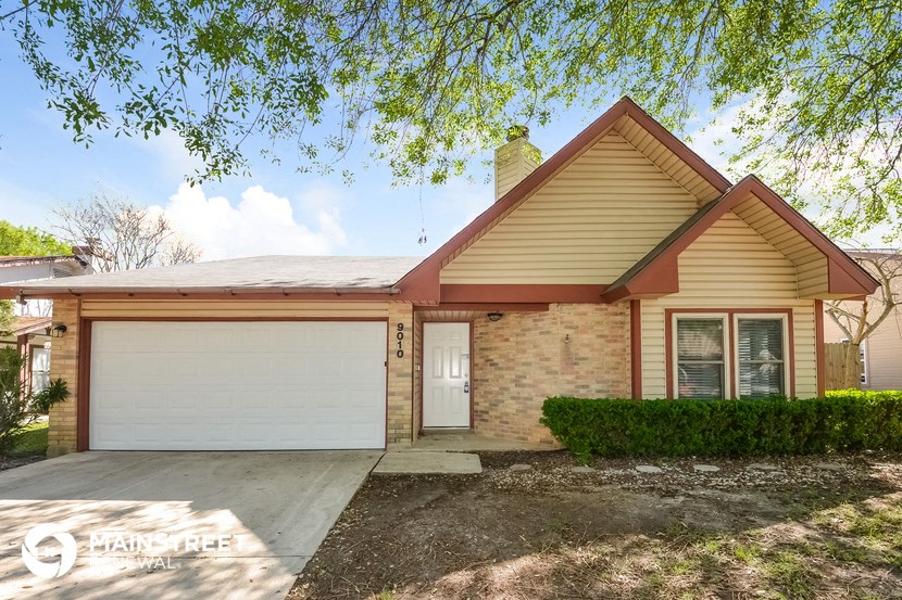 a home with a white garage door and a brick house