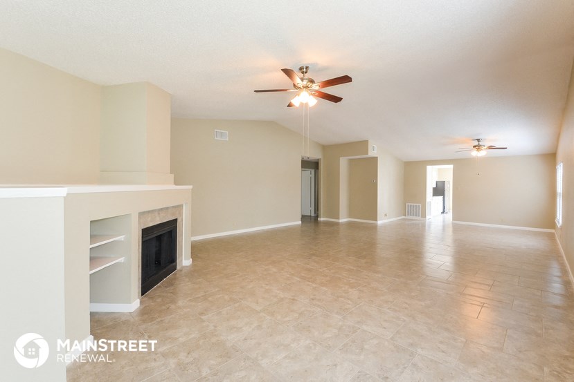 the spacious living room with fireplace and tile flooring