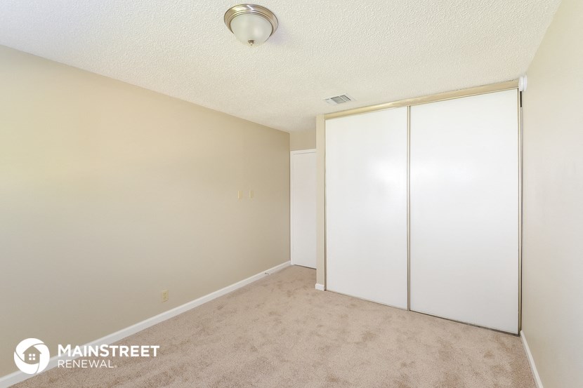 the living room of an apartment with two large white closets