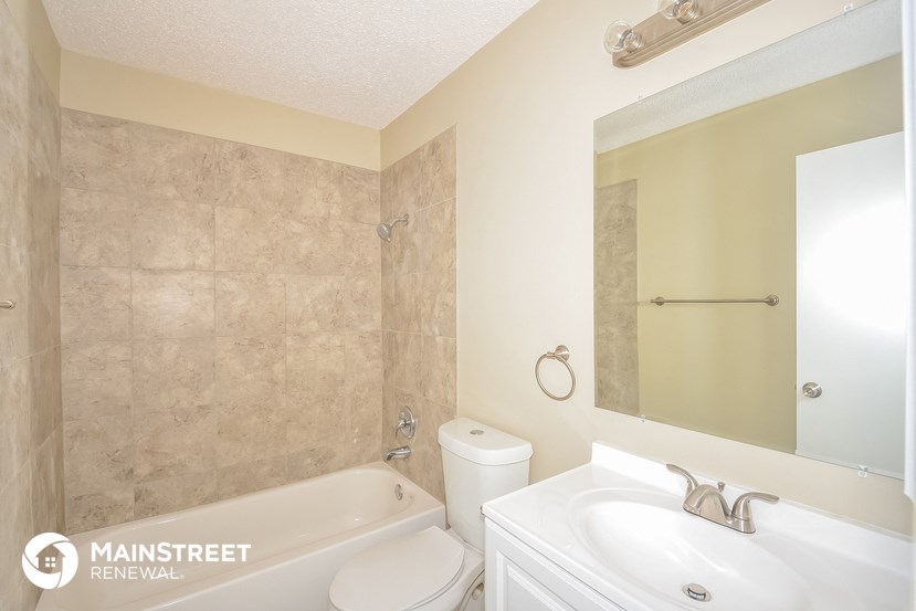 a bathroom with a tub and a sink and a mirror