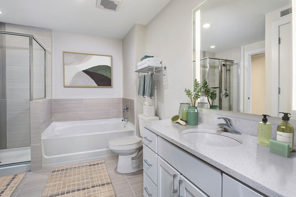 a white bathroom with a tub and a sink and a toilet