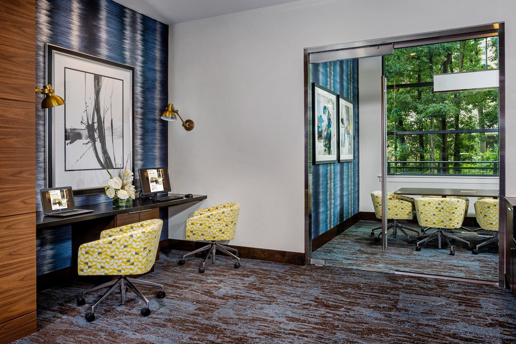 a conference room with a desk and chairs and a window