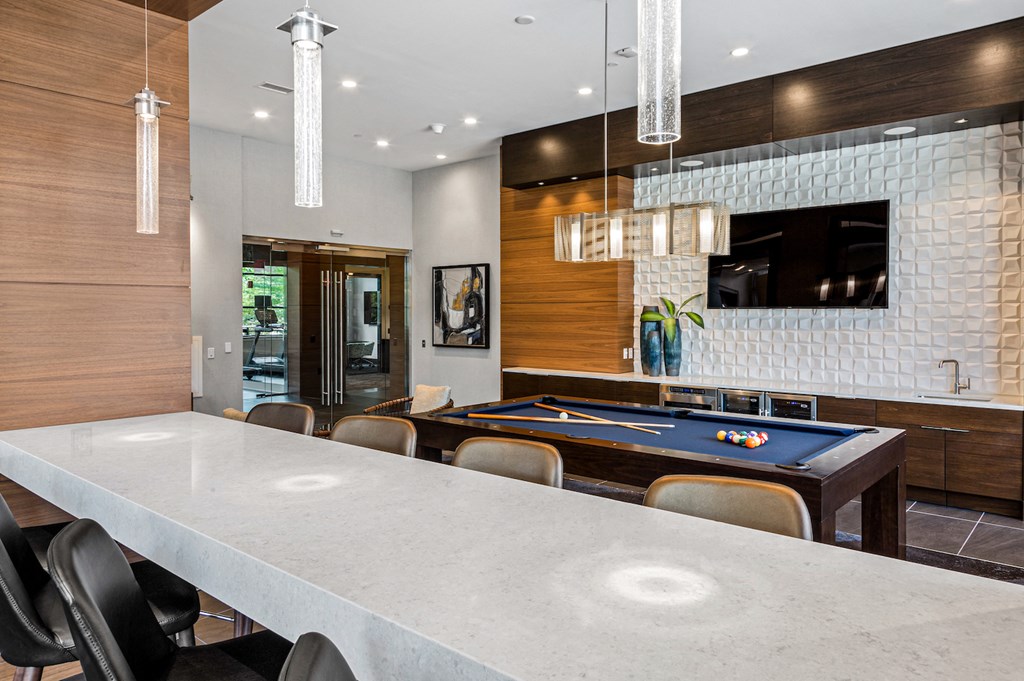 a large white kitchen with a blue pool table and a white counter top