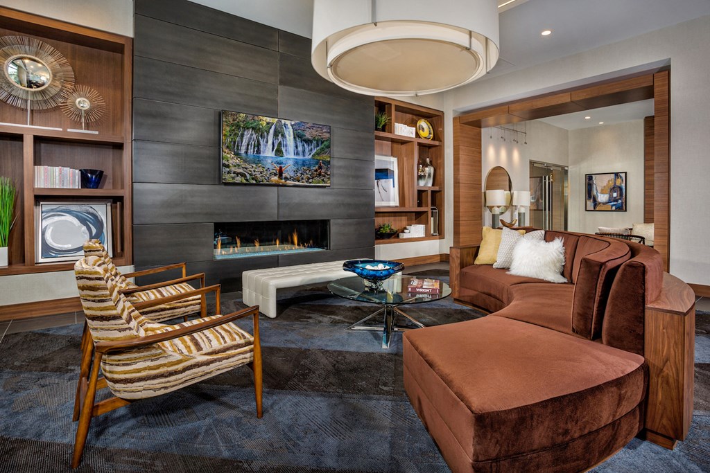 a living room with a brown couch and a fireplace