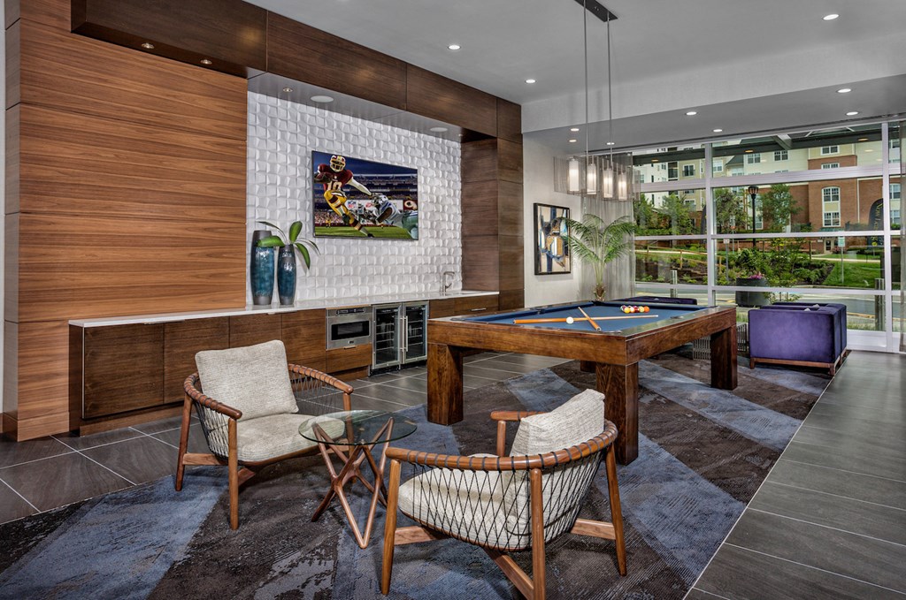 a billiards room with a pool table and chairs