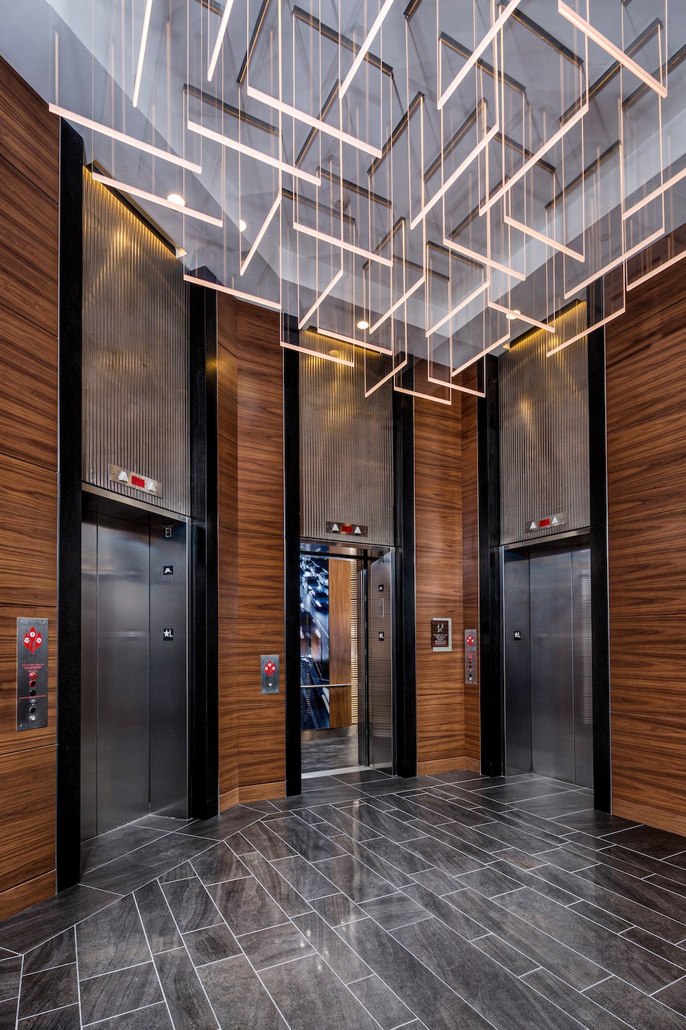 the lobby of a building with elevators and lighting