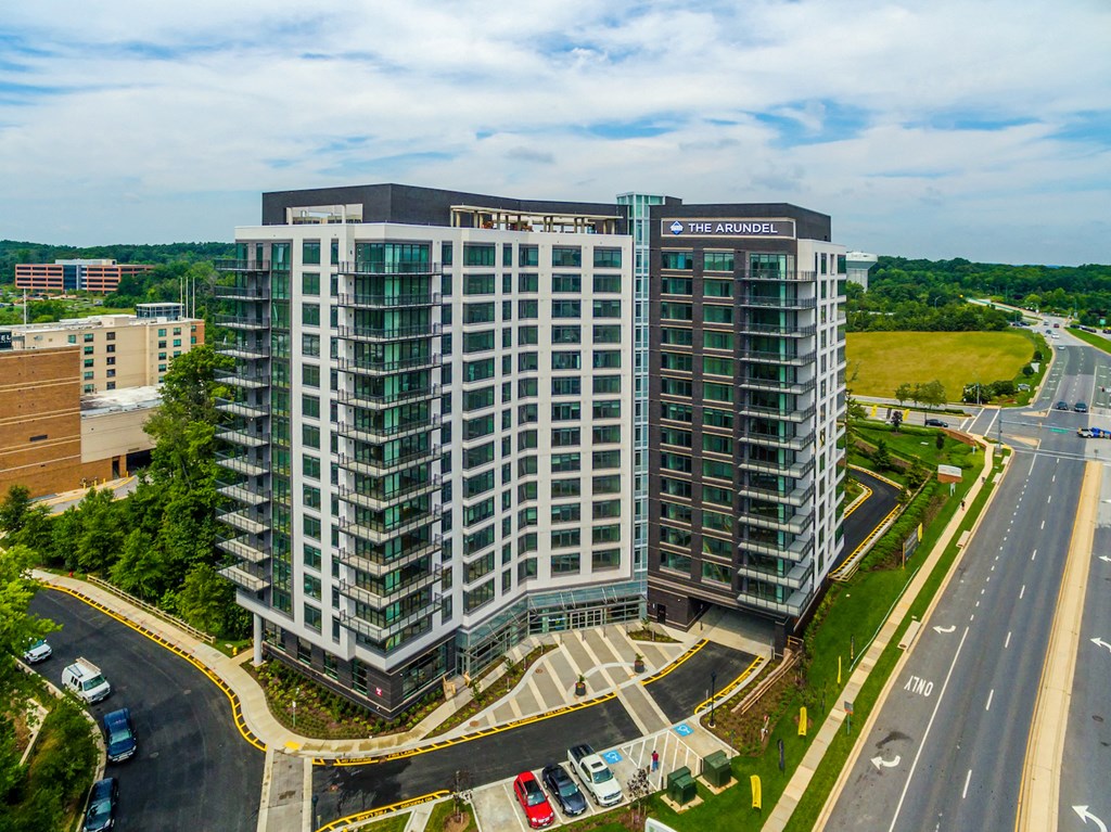 an aerial view of a tall building with a highway in the background