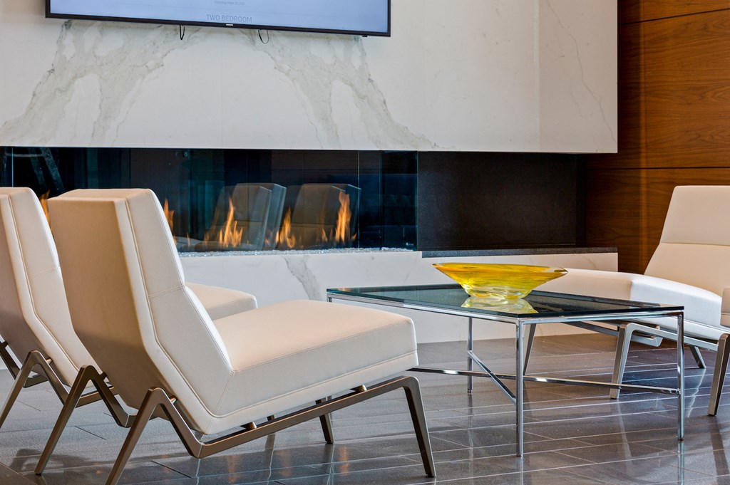 a group of chairs and a glass table in front of a fireplace