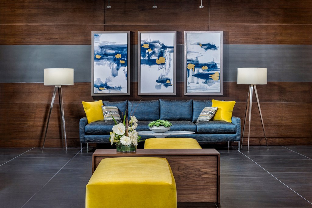 a living room with a blue couch and yellow pillows