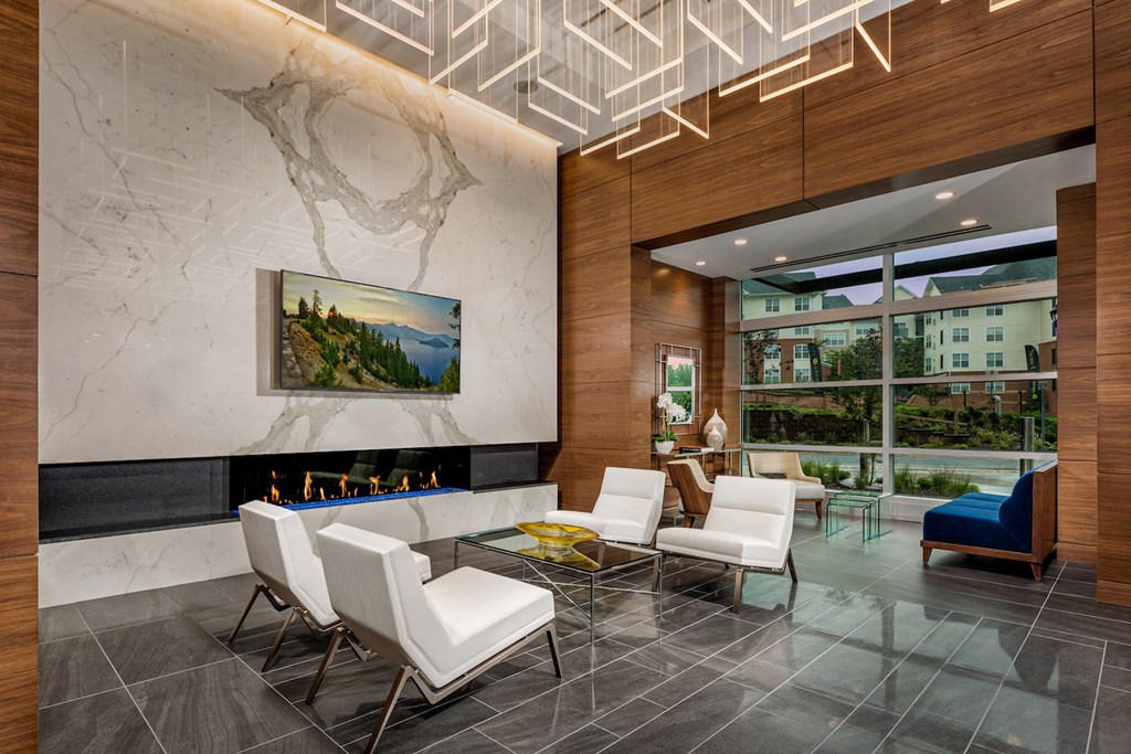a living room with white chairs and a fireplace and a large window